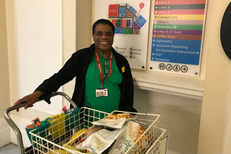 A Volunteer with the trolley around the hospital serving patients who maybe cannot get to the shop.