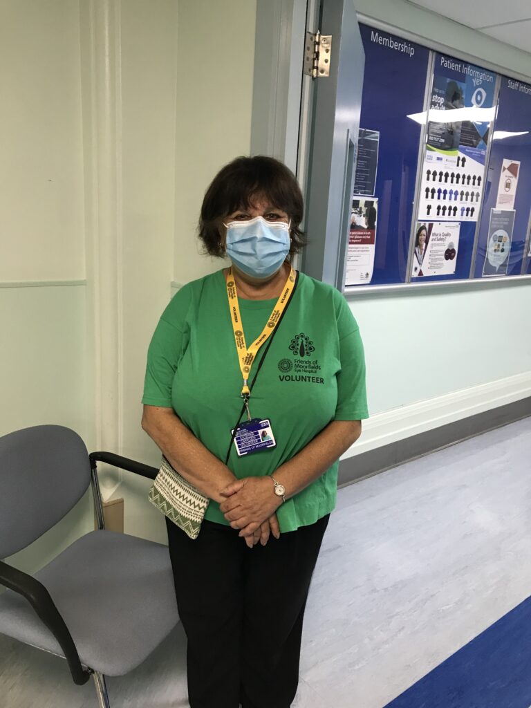 A female volunteer in a green T shirt wearing a face mask.