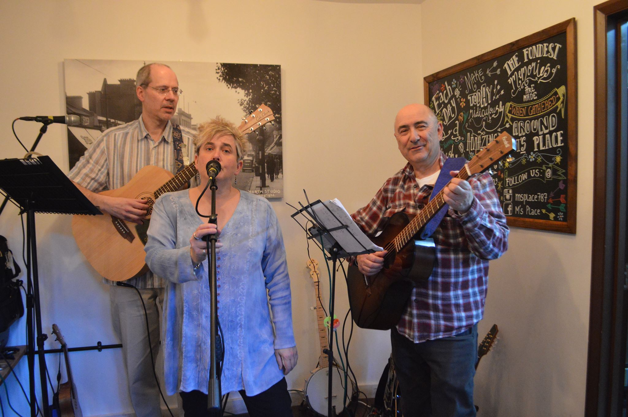 A three-piece acoustic band playing guitars and singing.