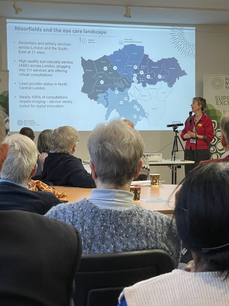 At the front of a room filled with attendees, Elena Bechberger presents a slide showing a map of London.