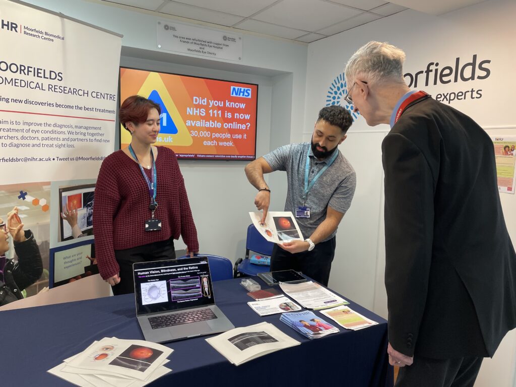 A researcher shows some images to a visitor.