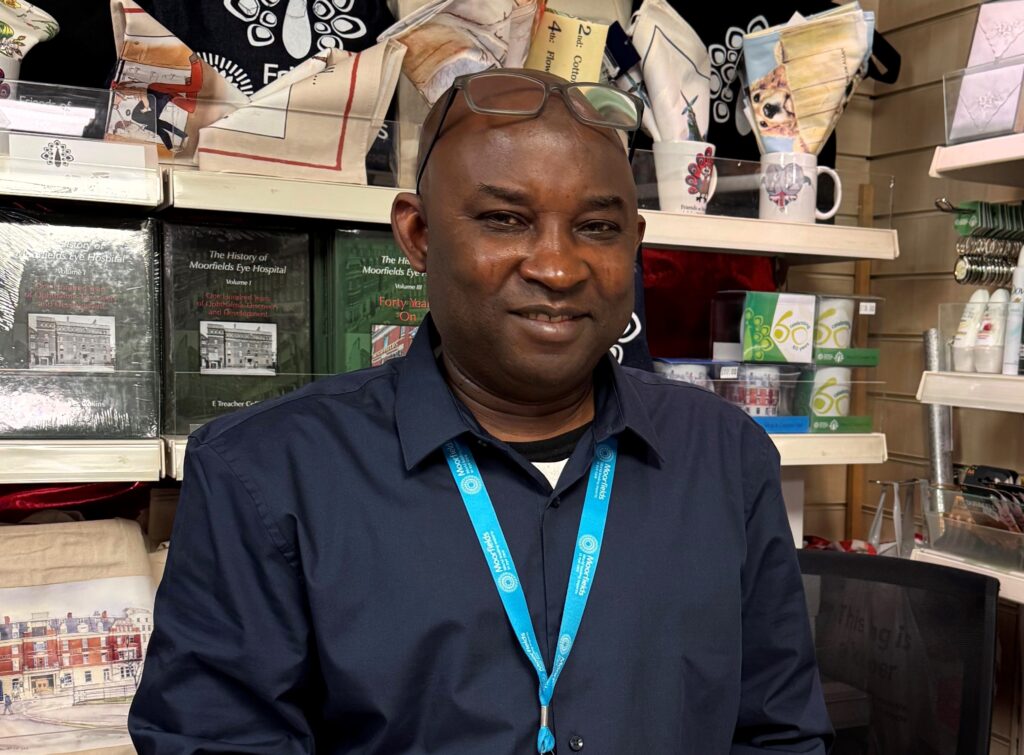 Abdul smiles behind the shop counter.